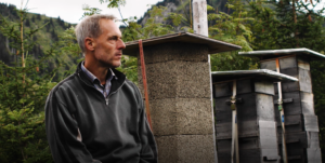 André Wermelinger à côté de ruches, Photo : Maurice Sinclair