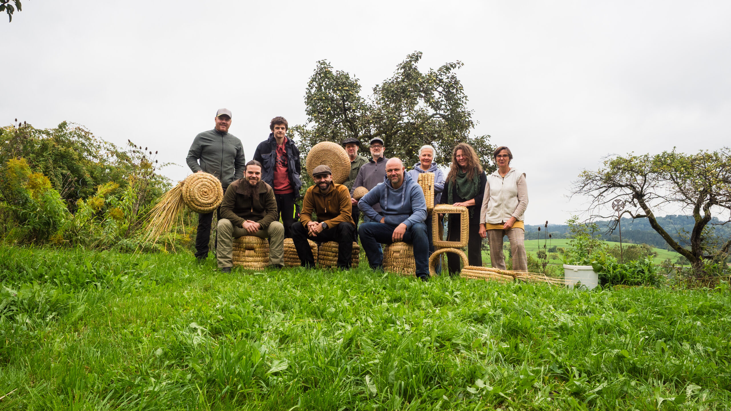 Participants au cours de vannerie lors de la photo de fin de cours avec les paniers à abeilles qu'ils ont eux-mêmes tressés