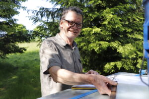 Ralph Büchler vor seiner Bienenbeute