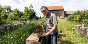 Dr. Ralph Büchler vor seinen Bienenstöcken im Garten